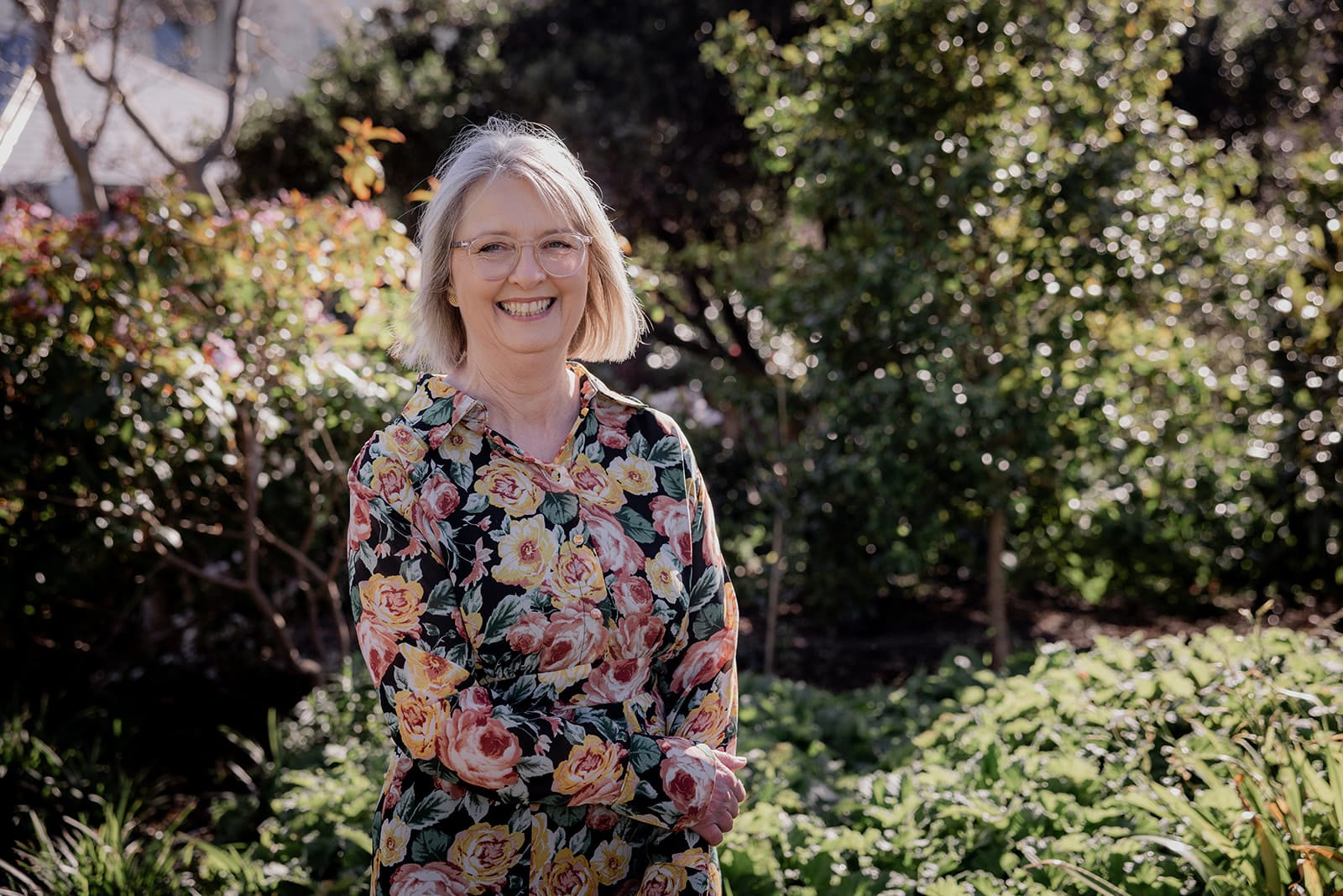 Mary Figg laughing in a sunlit garden