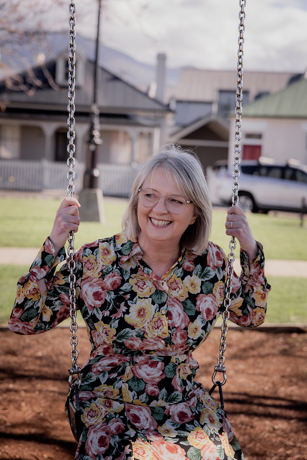 Mary Figg smiling on a swing outdoors